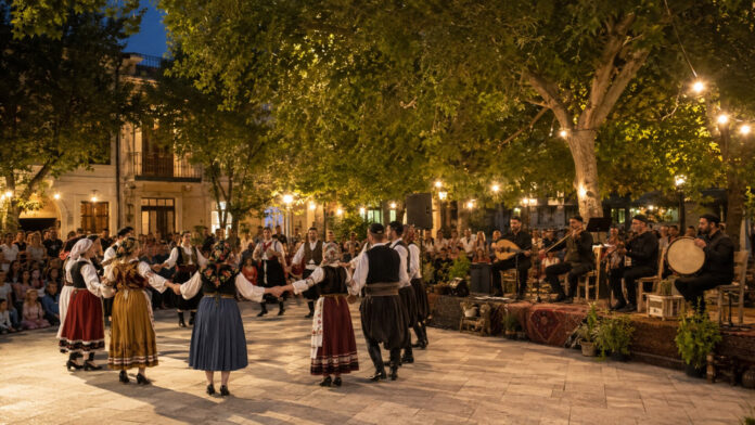 Χορευτές με παραδοσιακές φορεσιές και μουσικοί σε υπαίθρια πολιτιστική εκδήλωση