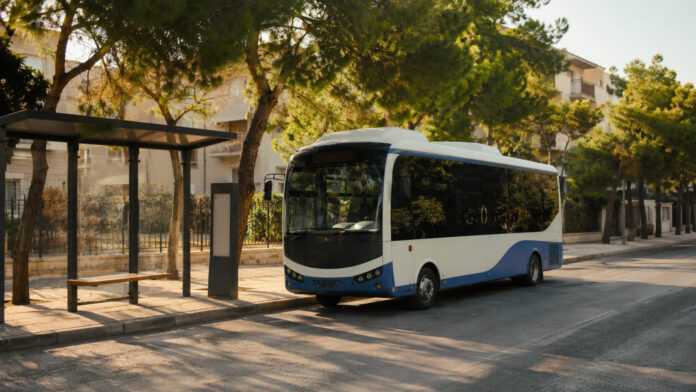 Δημοτικό λεωφορείο σε ήσυχη στάση σε δενδροφυτεμένο δρόμο