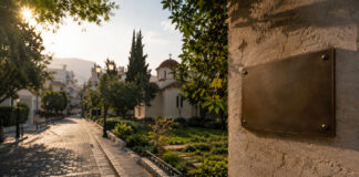 Χαλάνδρι: Οδός στη μνήμη του π. Σπυρίδωνα Παπαποστόλου Κενή μεταλλική πινακίδα ονοματοδοσίας σε ήσυχο δρόμο με πράσινο