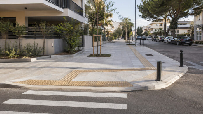 Νέο φαρδύ πεζοδρόμιο με όδευση τυφλών και προσβάσιμη ράμπα σε αστική οδό