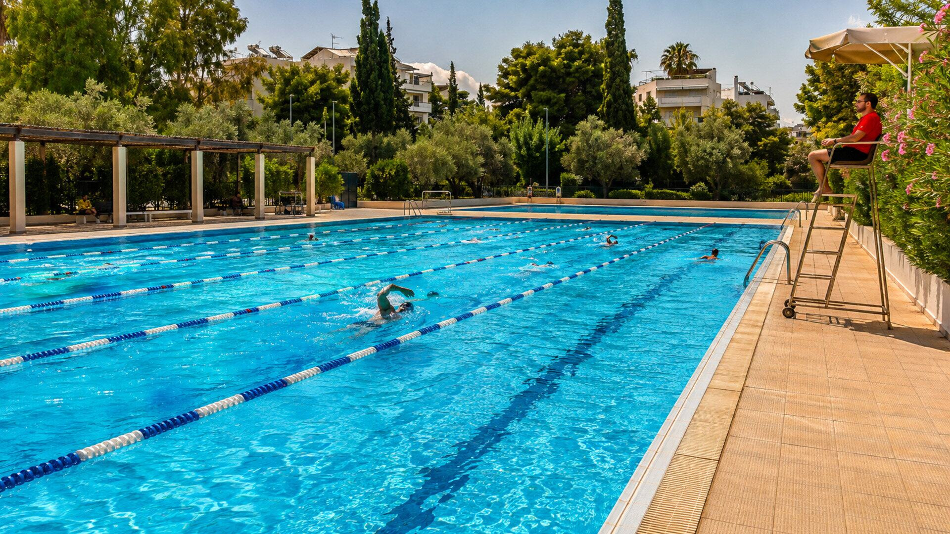 Κολυμβητές χρησιμοποιούν τις διαδρομές δημοτικού κολυμβητηρίου ένα καλοκαιρινό απόγευμα