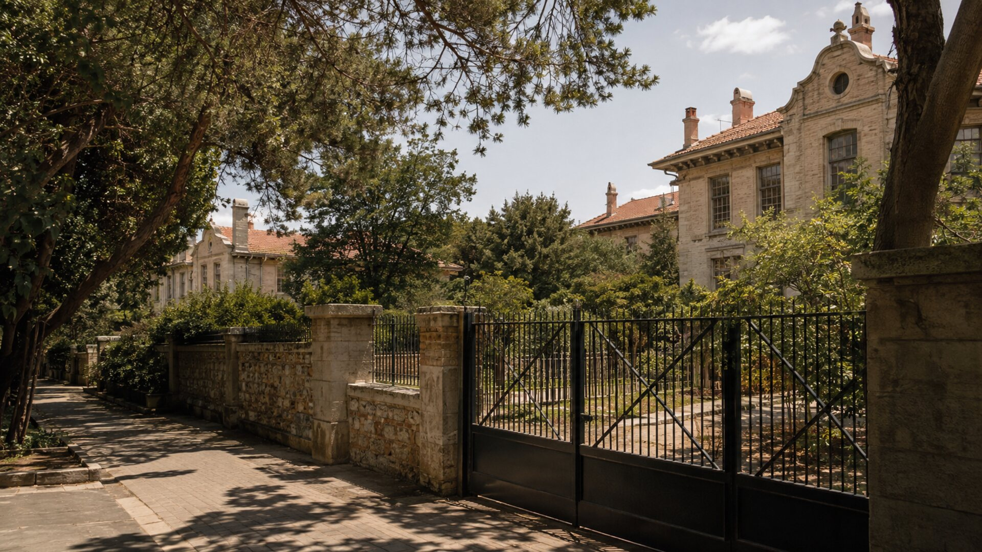 Ιστορικό κτίριο πίσω από κλειστή πύλη σε καταπράσινο αστικό κτήμα