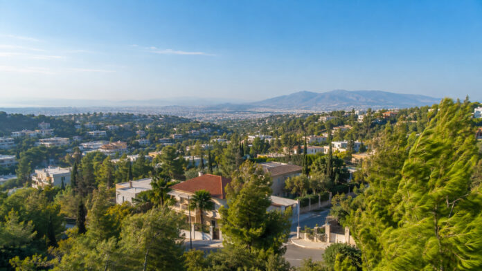 Ηλιόλουστη πανοραμική εικόνα των καταπράσινων βορείων προαστίων με τα δέντρα να κινούνται από τον βοριά