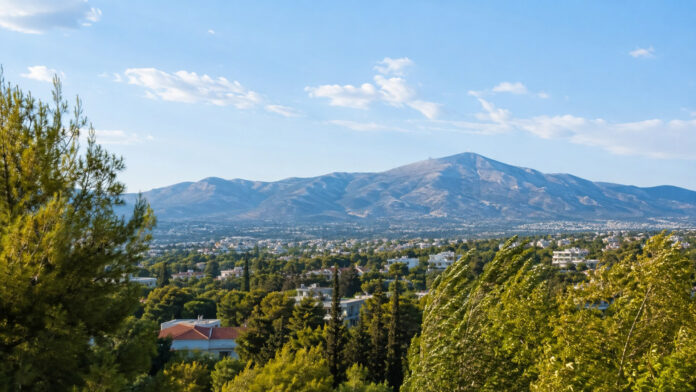 Ηλιόλουστη θέα των καταπράσινων βορείων προαστίων της Αττικής με την Πεντέλη και δέντρα στον βοριά