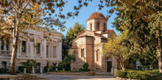 Κηφισιά: Η 26η Οκτωβρίου καθιερώθηκε ως νέα τοπική αργία Ψηφιακή editorial απεικόνιση ήσυχης πλατείας με ορθόδοξο ναό σε φθινοπωρινό τοπίο