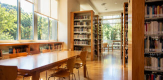 Λυκόβρυση–Πεύκη: Κλειστή η Δημοτική Βιβλιοθήκη έως 31 Αυγούστου Ψηφιακή editorial απεικόνιση ήσυχου αναγνωστηρίου δημοτικής βιβλιοθήκης κατά τη θερινή περίοδο
