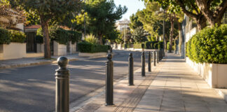 Νέα Ερυθραία: Προστατευτικά εμπόδια στην οδό Ισμήνης Προστατευτικά μεταλλικά εμπόδια κατά μήκος πλατιού πεζοδρομίου σε καταπράσινο αστικό δρόμο