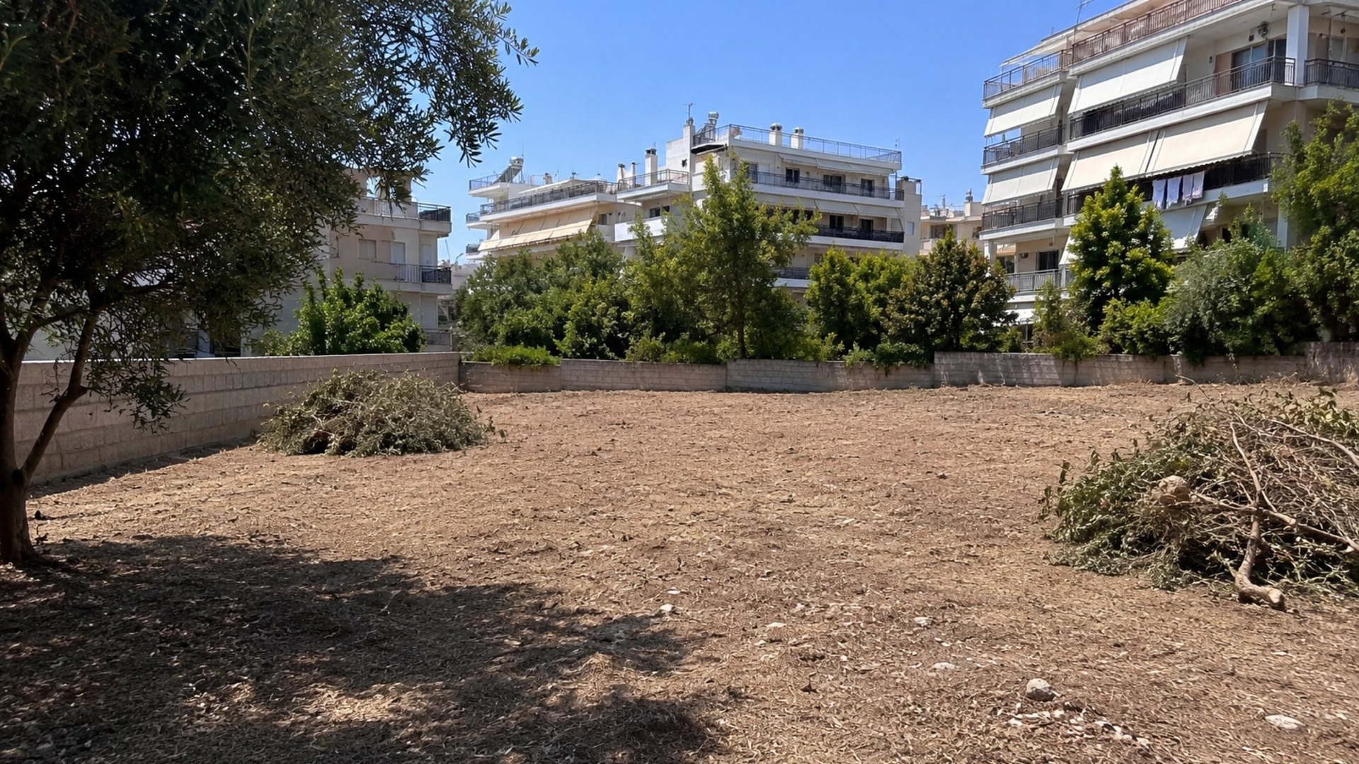 Καθαρισμένο οικόπεδο χωρίς ξερά χόρτα ανάμεσα σε κατοικίες της Νέας Ιωνίας