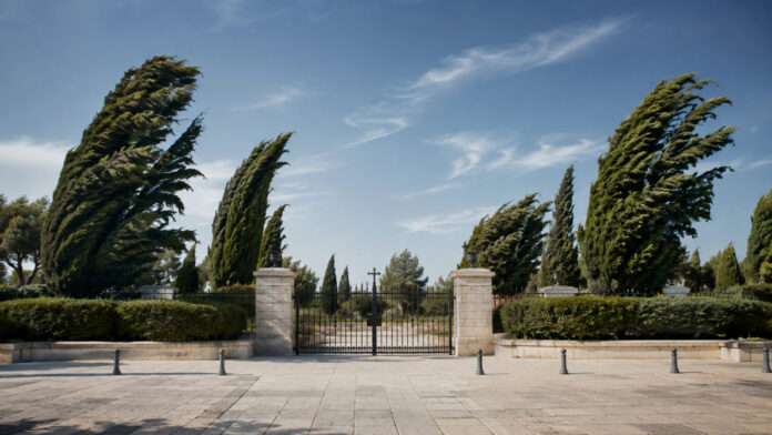 papagou-cholargos-koimitiria-anemoi-20260813-1300-1920x1080-1 Κυπαρίσσια λυγίζουν από ισχυρό άνεμο μπροστά σε κλειστή είσοδο κοιμητηρίου