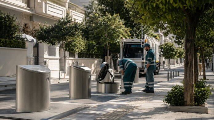 Σύγχρονοι υπογειοποιημένοι κάδοι απορριμμάτων σε καθαρό αστικό δρόμο