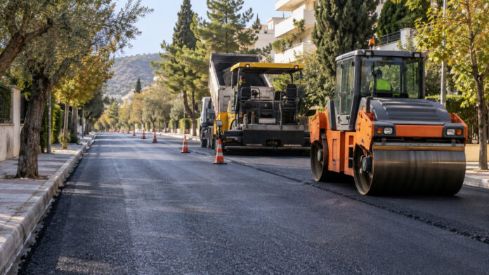 Μηχανήματα οδοστρωσίας σε δενδροφυτεμένο αστικό δρόμο