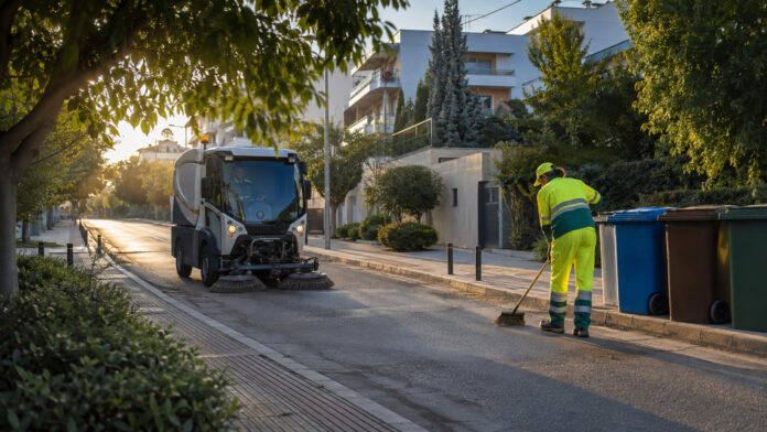 Δημοτικό σάρωθρο και εργαζόμενος καθαριότητας σε δρόμο κατοικιών