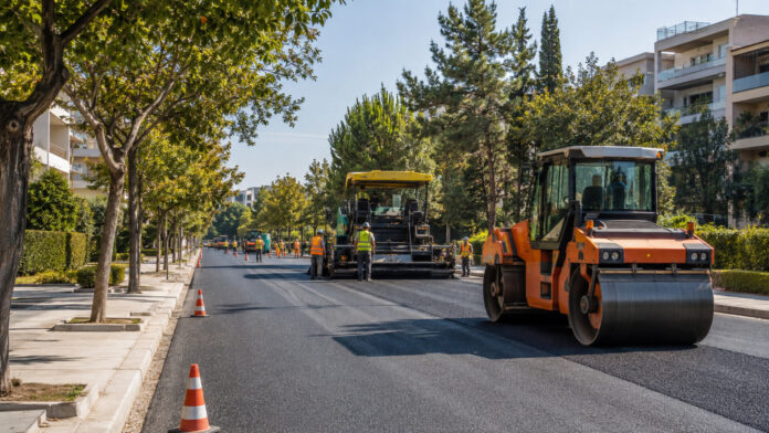 Οργανωμένες εργασίες ασφαλτόστρωσης σε δενδροφυτεμένη αστική λεωφόρο