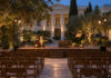 Κηφισιά: «Το Μόνον της Ζωής του Ταξείδιον» στα Μενάνδρεια Υπαίθρια θεατρική σκηνή σε φωτισμένο νεοκλασικό αίθριο με βιβλίο και παλιό ταξιδιωτικό μπαούλο