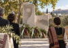 Νέα Ερυθραία: Τελετή μνήμης για τα θύματα της Μικρασιατικής Καταστροφής Στεφάνια και πολίτες μπροστά σε πέτρινο μνημείο σε δενδροφυτεμένη πλατεία