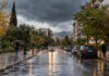 Αττική: Ισχυρές βροχές και καταιγίδες την Τρίτη 13 Οκτωβρίου Βροχερός δρόμος σε αστική γειτονιά της Αττικής με πεζούς που κρατούν ομπρέλες
