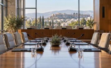Φιλοθέη–Ψυχικό: 16 θέματα στη Δημοτική Επιτροπή της 6ης Οκτωβρίου Σύγχρονη αίθουσα συνεδριάσεων με μικρόφωνα και φακέλους πάνω σε ξύλινο τραπέζι