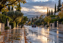 Καιρός στην Αττική: Ψυχρό πρωινό και σταδιακή βελτίωση Συννεφιασμένο φθινοπωρινό πρωινό με βρεγμένο δρόμο και πράσινο στα βόρεια προάστια